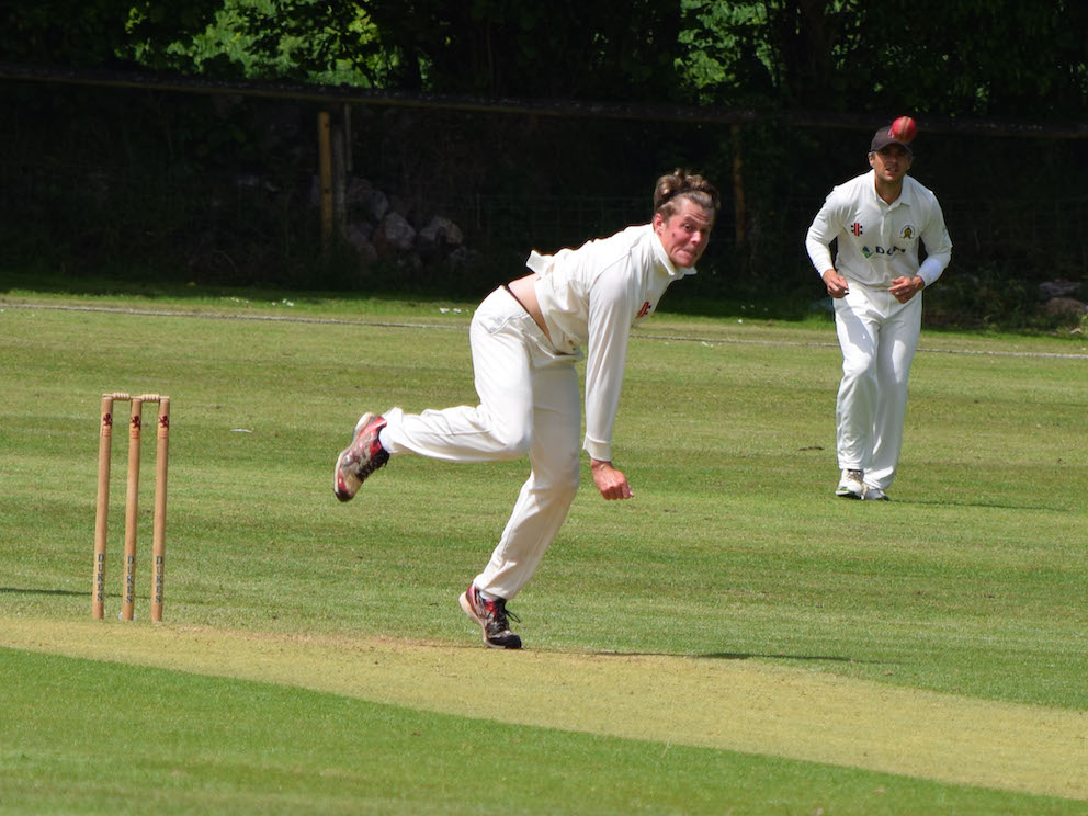 Alex Burt bowling down the hill at Abbotskerswell against Budleigh Salterton