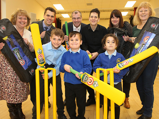 Nick Henderson and Rachel Anderson-Stacey (in the middle of the back row) handing over Kwik Cricket bags to primary school head teachers