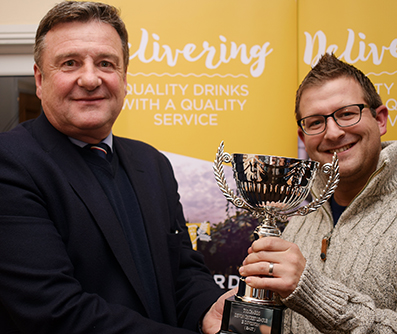 Honiton's Ian Kelly (right) receiving the Tolchards DCL E Division East champions trophy from league sponsor Jim Mardell