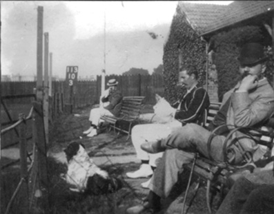 A photo dated 1894 of H B Mapleton sitting in the pavilion enclosure at South Devon during a game