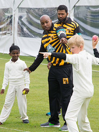 Tino Best passing on tips to Plymouth youngsters before the Lashings All Stars day at Mount Wise earlier this year