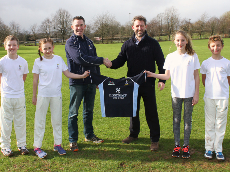 Nathan Stone presenting a new T20 junior shirt to Ipplepen’s junior chairman Andrew Maynard, supported by junior members (left to right) Max Stone, Zoe Maynard, Maggie Winslow and Edward Winslow