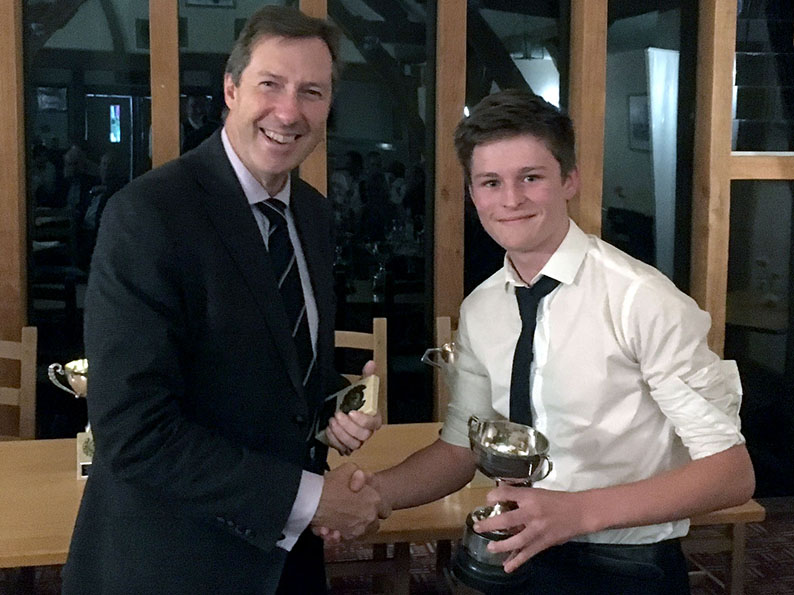 Best young cricketer Morgan Hargreaves accepting his trophy from Chris Hart