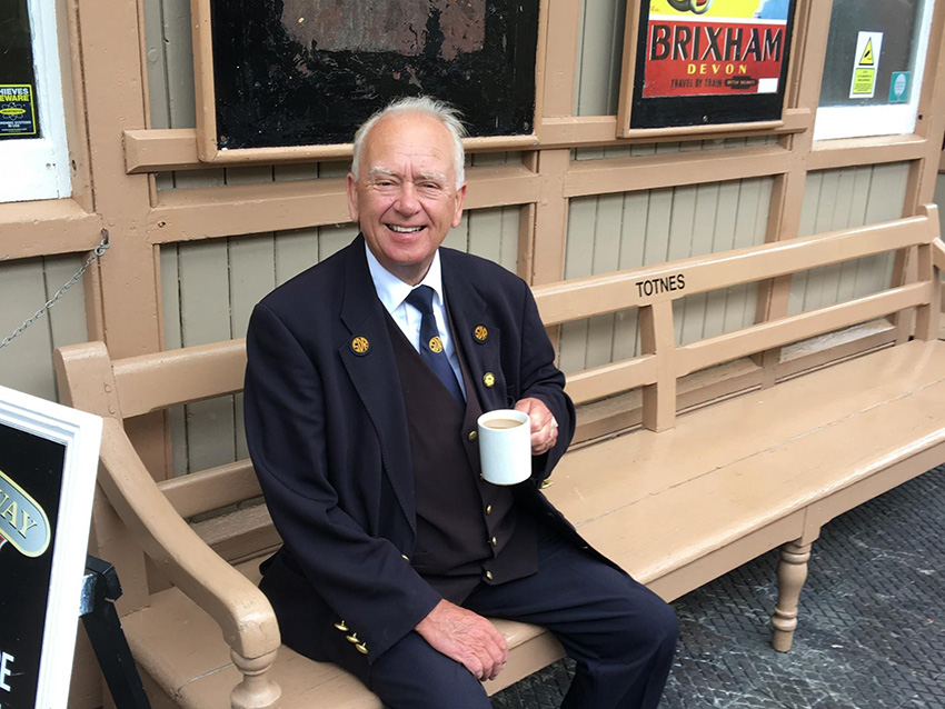 Joe Clowes relaxing on the platform at Totnes Riverside station with a cup of tea