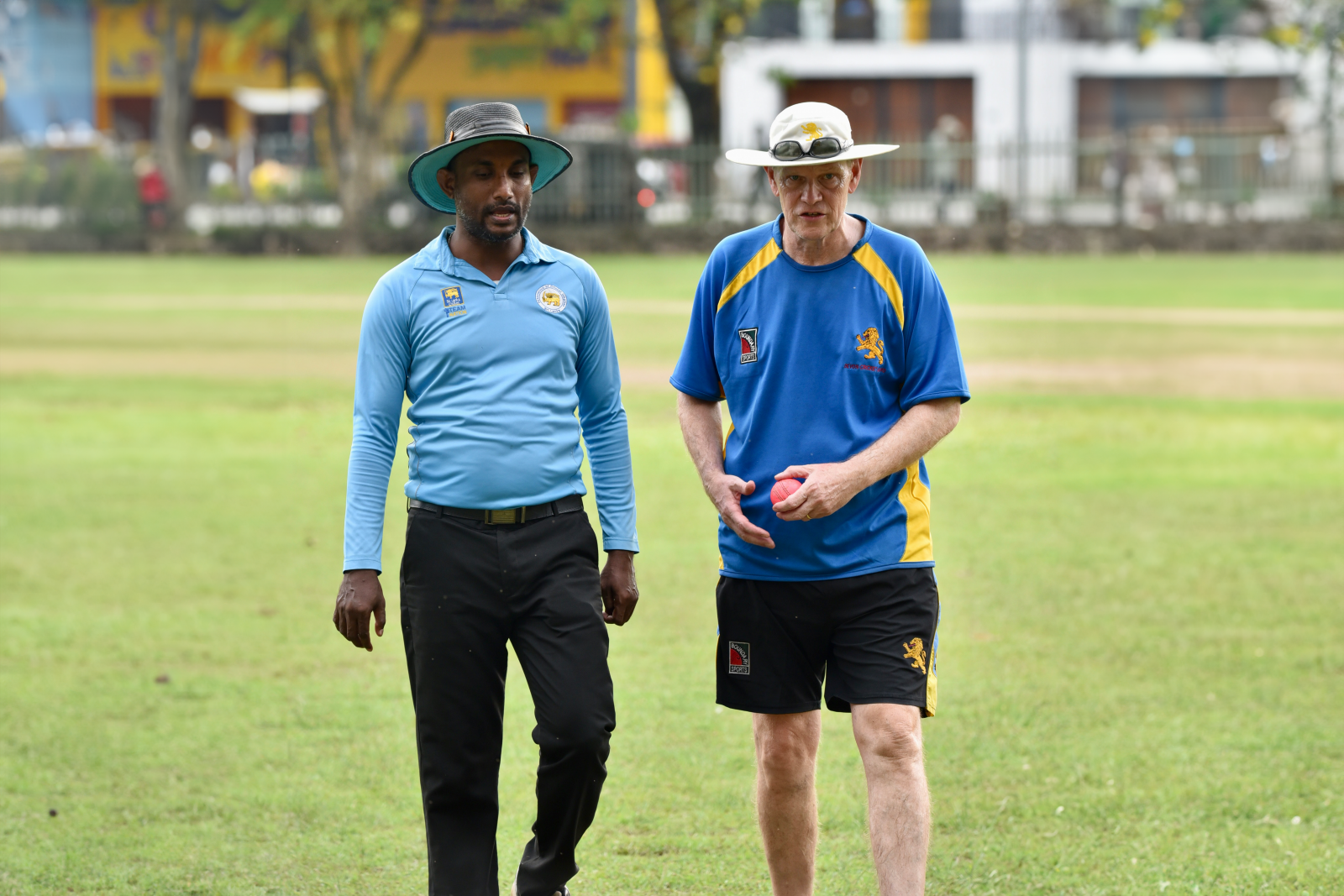 David Joseph (right) speaks to an umpire in the game against Mercantile Cricket Association Girls.