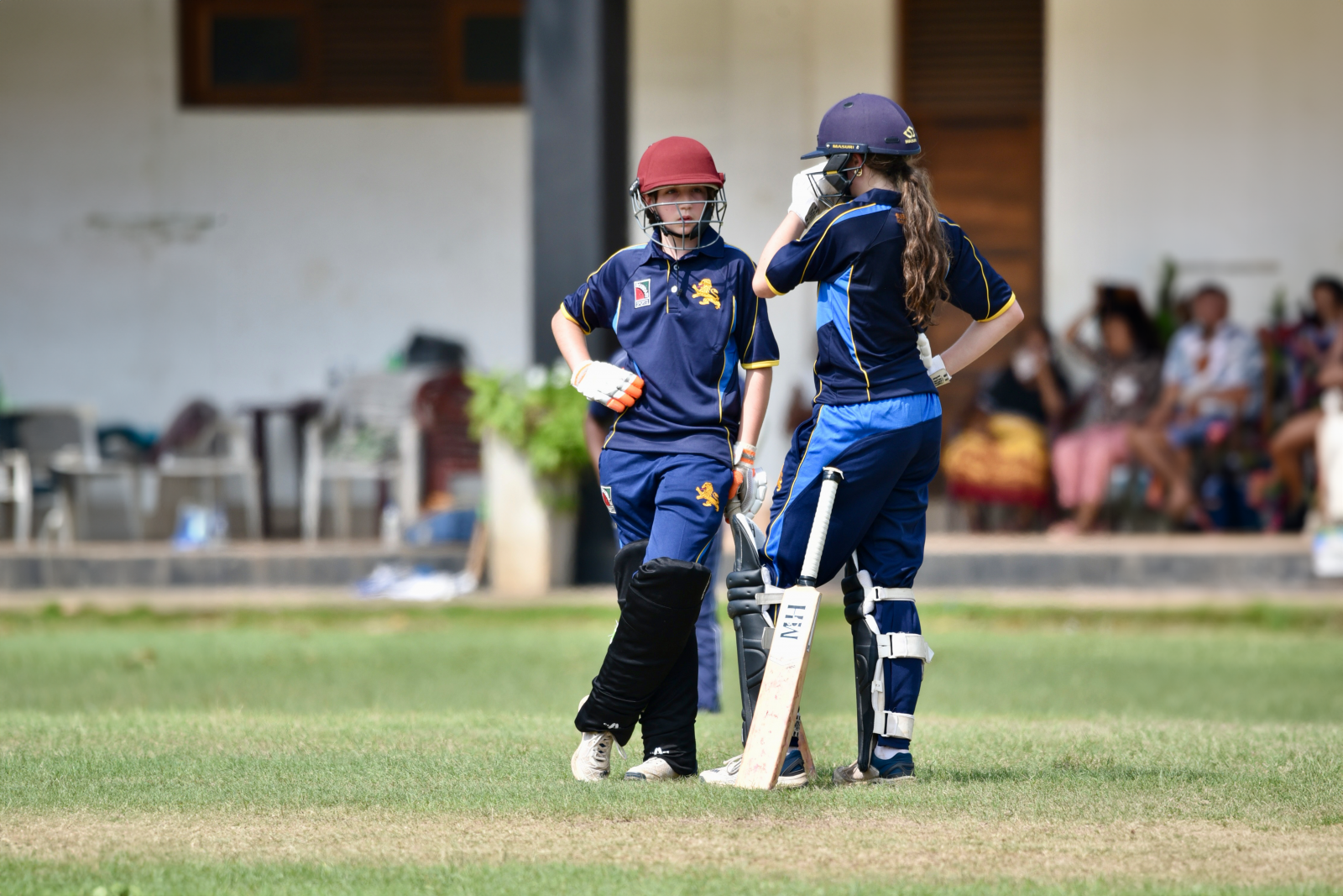 Maggie Haffenden (left) speaks to Lily Innes at the crease during the game against Mercantile Cricket Association Girls.