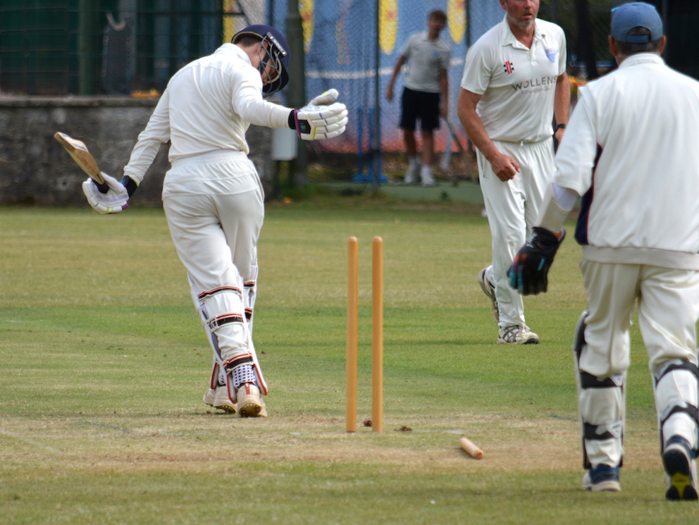 Paignton's Arthur Rae about to trudge off after having his off-stump flattened by South Devon's Jonny Martin