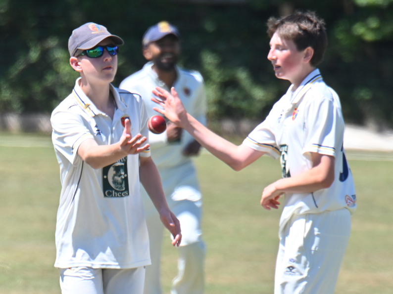 Will Manning (left) chucks the ball back to Nelson Stanley after taking a catch off his team-mate's bowling