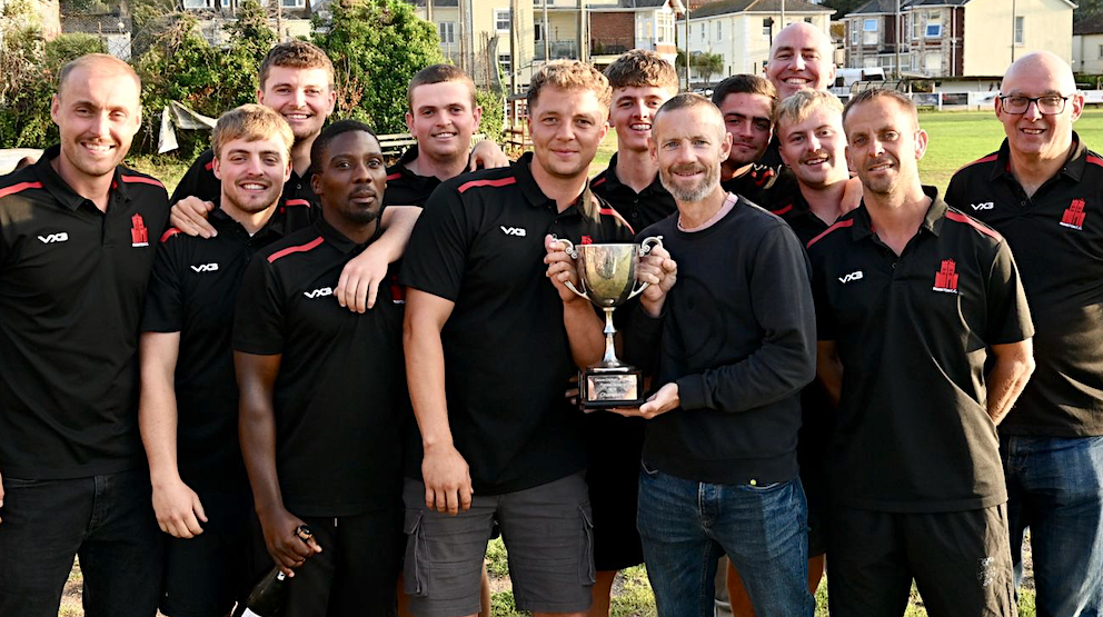 Paignton captain Harry Ward and Chris Read have a hand each on the Tolchards DCL Premier Division trophy<br>credit: Jen Kirkup
