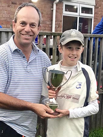 Winning captain Matt Jeacock collects the cup from Cullompton chairman Richard Stevenson